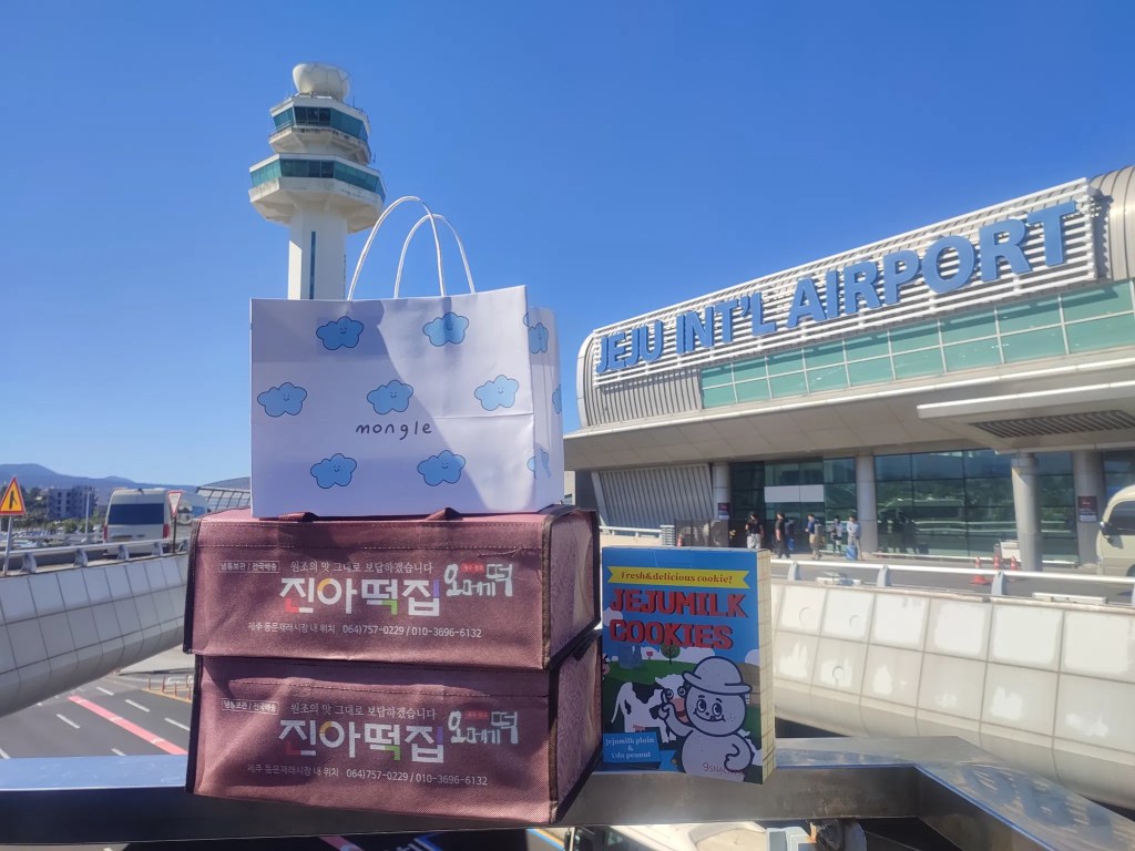 진아떡, 몽그레, 제주우유쿠키가 담긴 제주드림 선물박스를 제주공항 앞에서 촬영한 모습